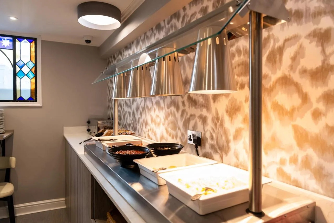 a kitchen with a counter with some pans on it at Byron Hotel in London